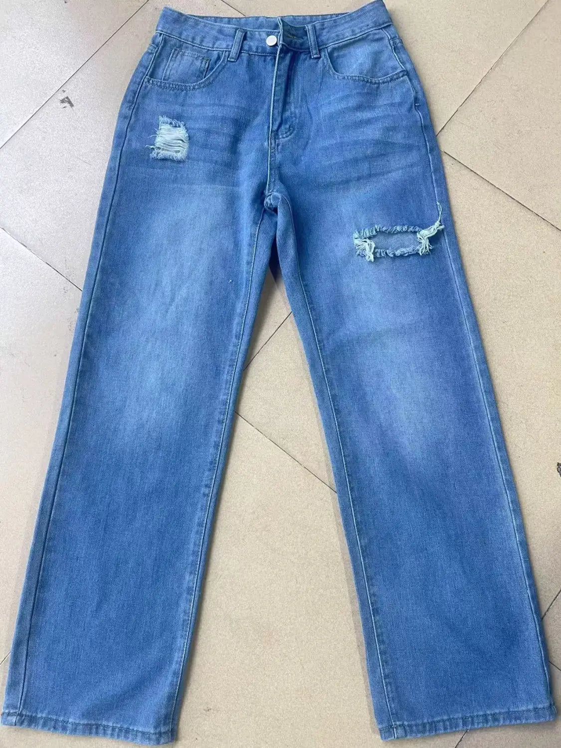 distressed high rise wide leg denim jeans in blue featuring frayed and distressed patches on the knees made from denim material