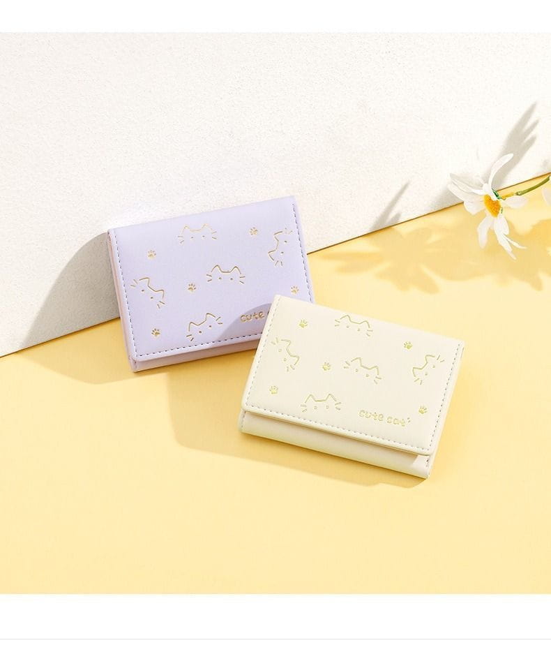 women’s small cat print folding leather wallets in pastel lavender and cream colors featuring gold foil detailing and cat-themed design
