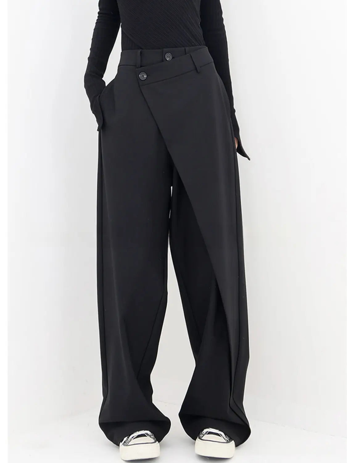 Schwarze asymmetrische Weitbein-Hosen mit modernem asymmetrischem Design und geknöpfter Bundlösung.