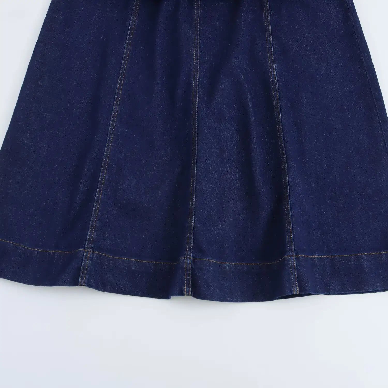 Navy crew neck sleeveless denim A-line dress featuring a dark blue denim skirt with visible stitching along the seams and hem.