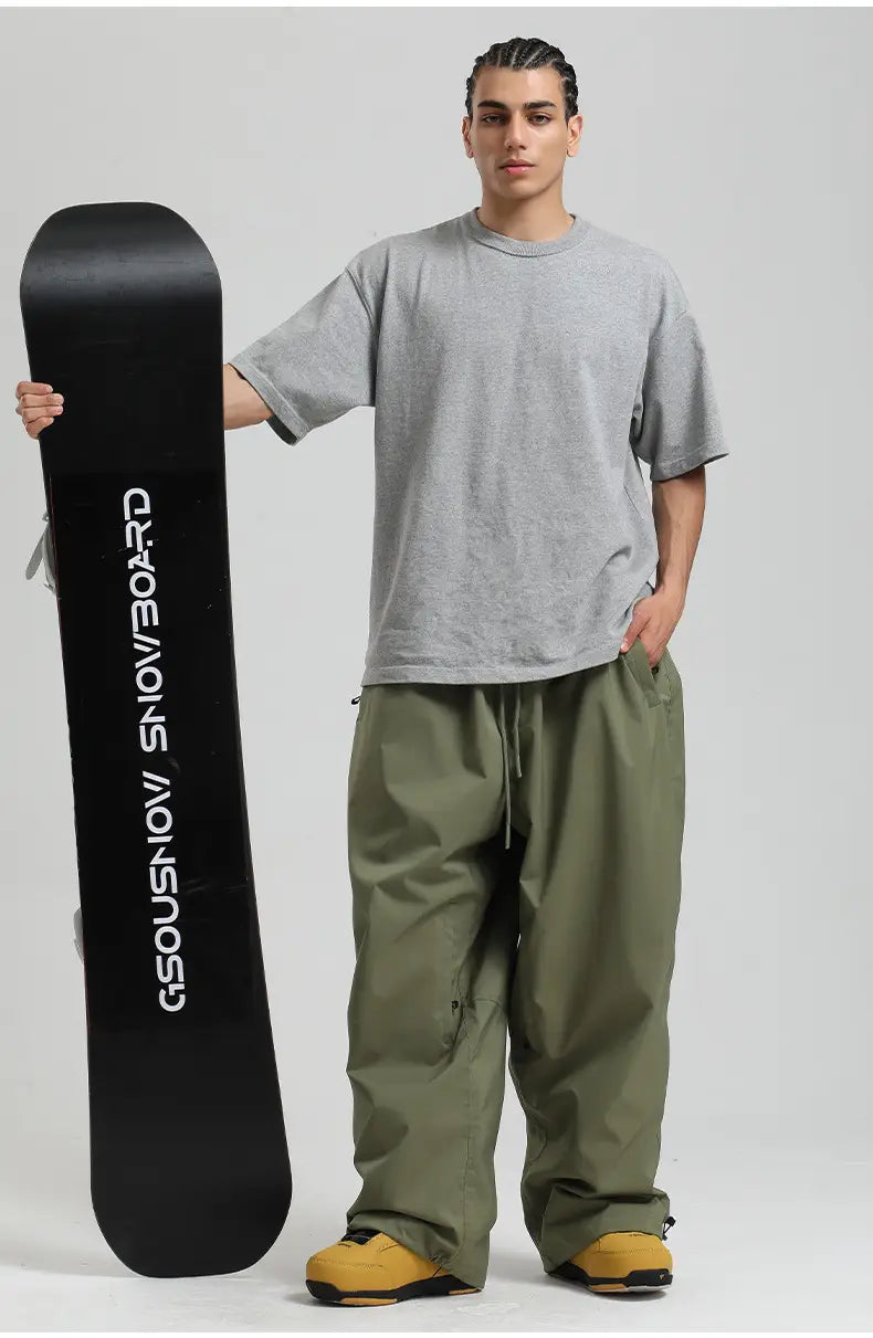 A black snowboard featuring white gsousnows branding accompanies waterproof windproof snow pants loose work trousers designed for durability and comfort in harsh weather conditions.