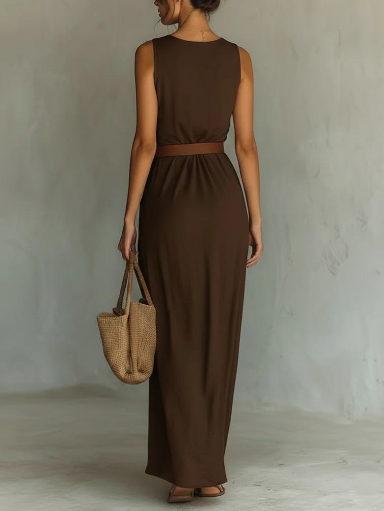A sleek brown satin sleeveless maxi dress with a cowl neck, fitted waistband, and flowing draped fabric ideal for resort wear.