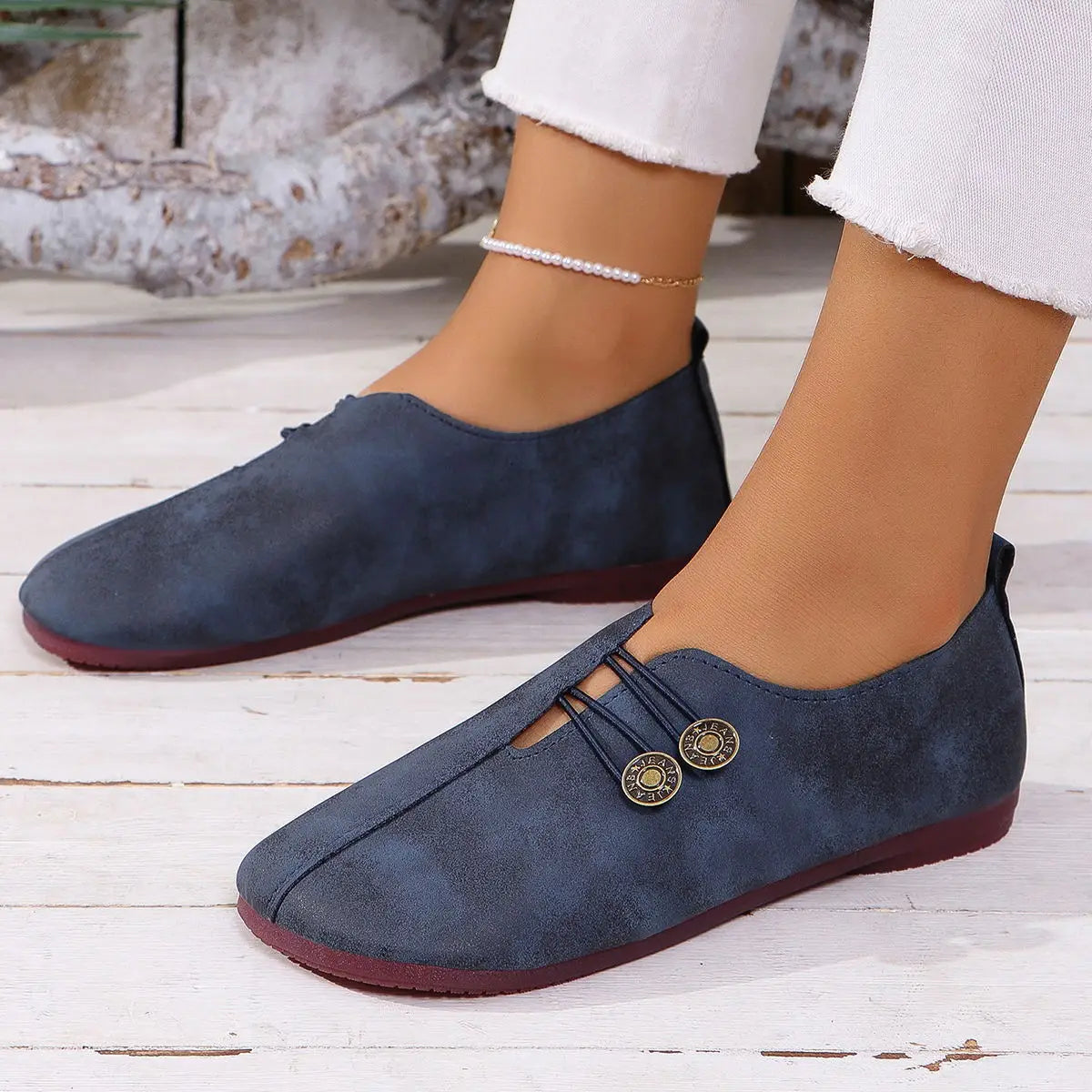 Navy blue suede flat women’s square toe lace-up leather and suede loafers with decorative gold-toned button accents.