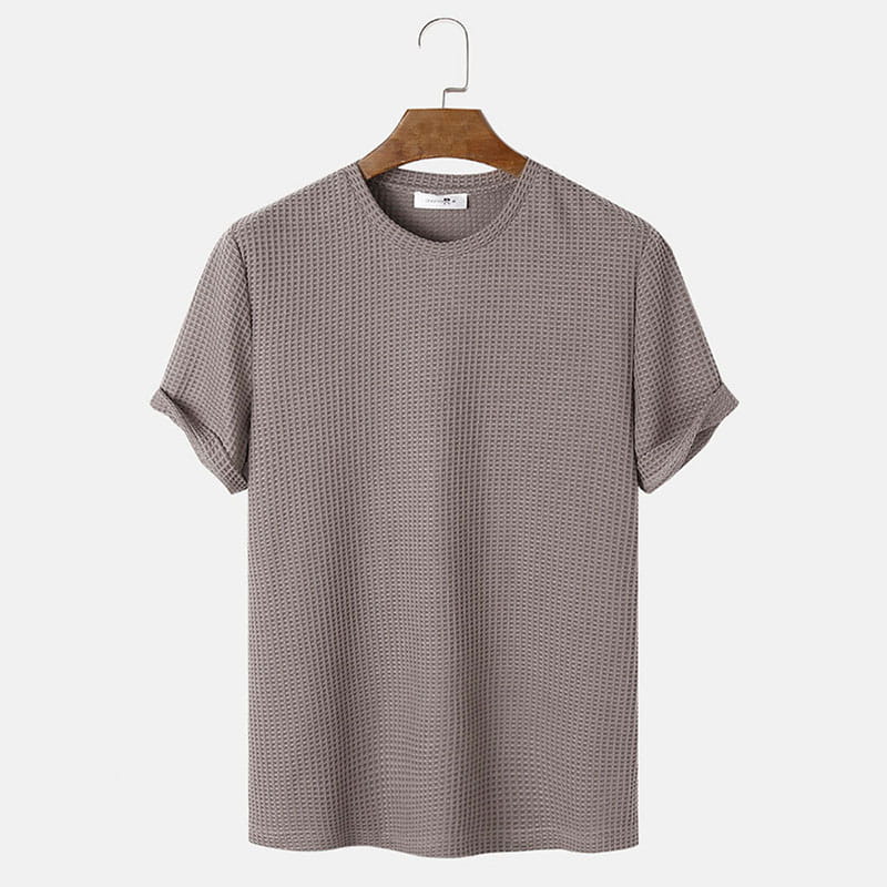 Herren-T-Shirt in Slim-Fit aus Waffelstrick als Henley in grauer Baumwolle mit hochgekrempelten Ärmeln, auf einem Holzkleiderbügel hängend