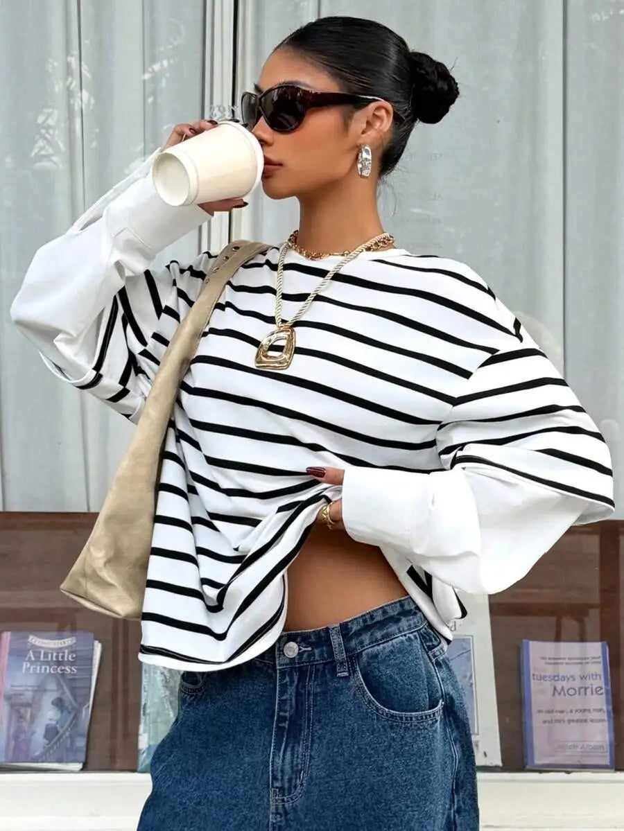 Top corto de manga larga con rayas horizontales negro y blanco con mangas globo, como parte de la colección de sudadera oversize tipo conjunto falso de dos piezas con rayas