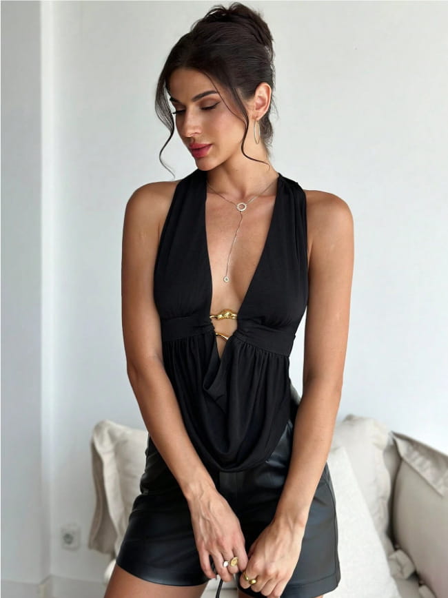 Black satin halter romper with faux leather shorts featuring a gold-toned metallic belt detail at the waist.