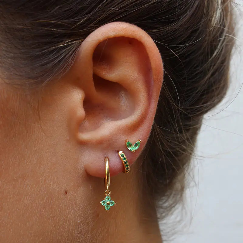 Gold hoop earring with a dangling green gemstone flower pendant from the floral and butterfly gold hoop earring set with gemstones.