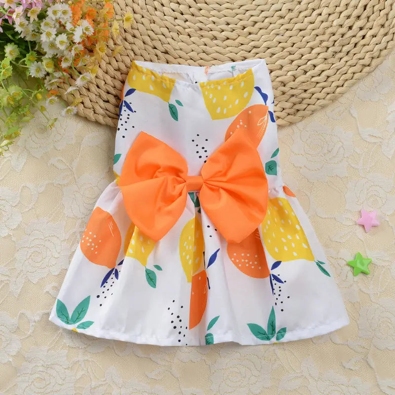 white skirt with vibrant citrus fruit print and oversized orange bow at the waist from the floral dog princess dress strawberry daisy pet apparel collection
