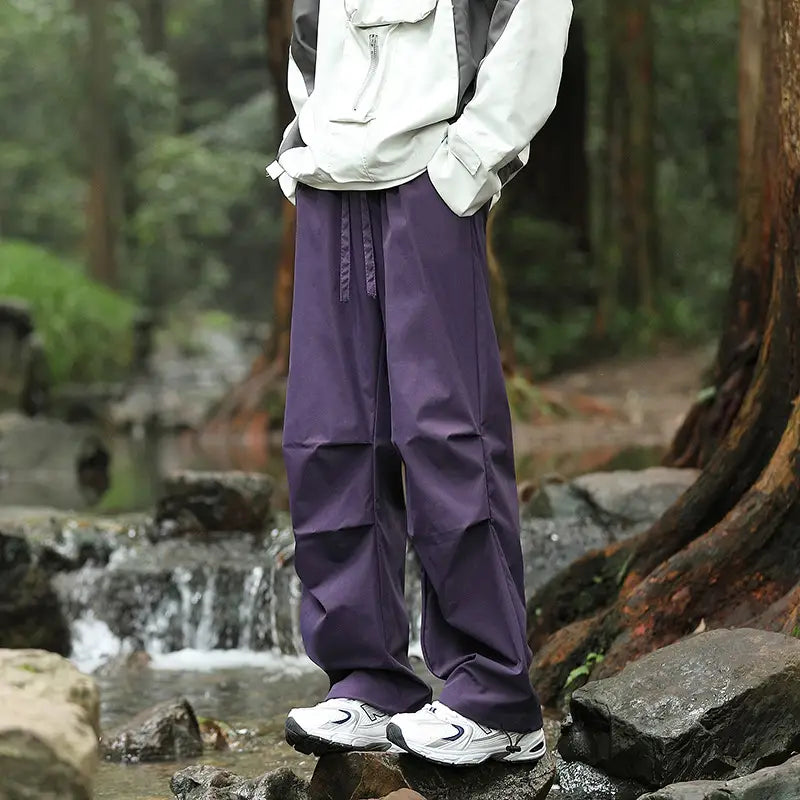 pleated cargo hiking pants for men and women in purple wide-leg design with a drawstring waist and subtle vertical stitching details.