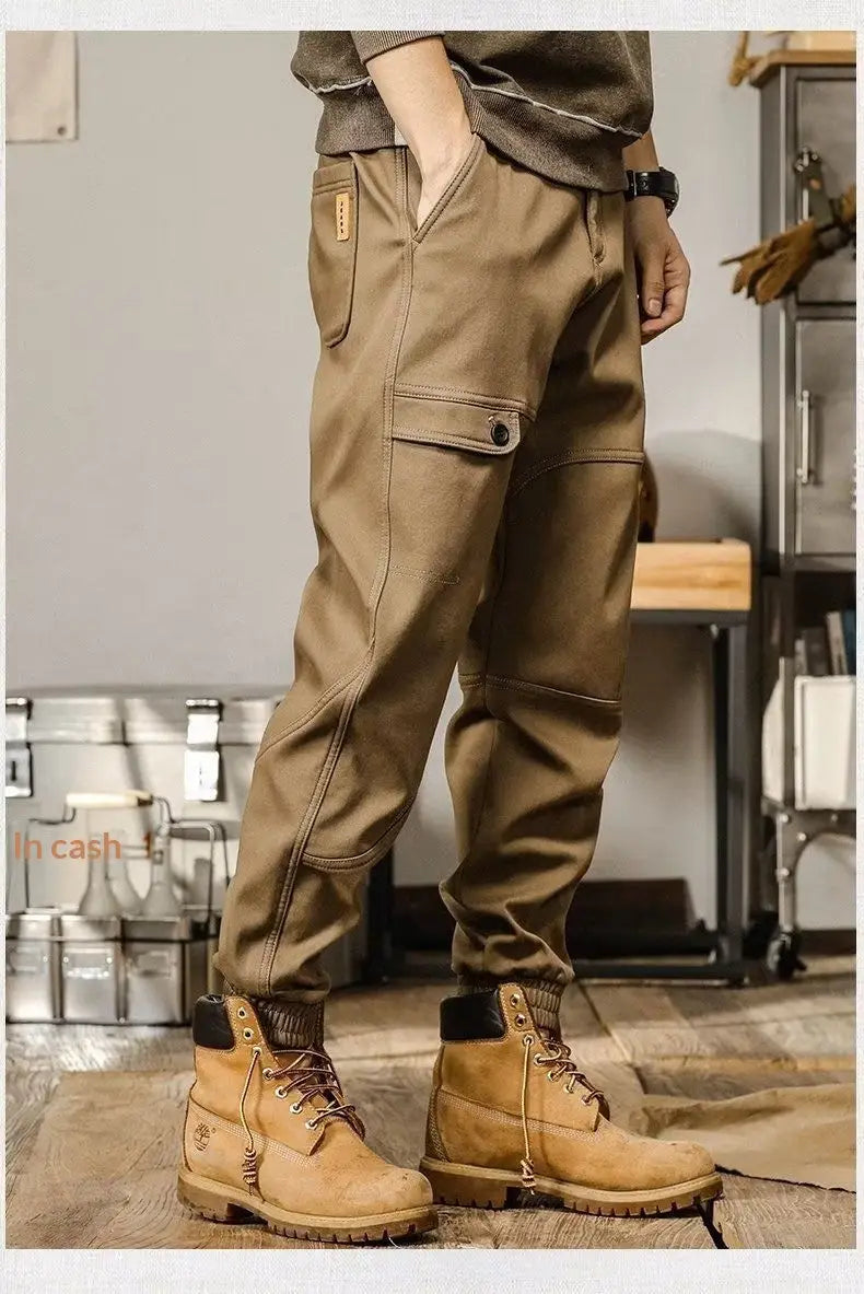 Pantalons cargo pour hommes à coupe ample, style décontracté et vêtement de travail, en tan, avec plusieurs poches et un tissu durable, portés avec des bottes Timberland tan assorties.