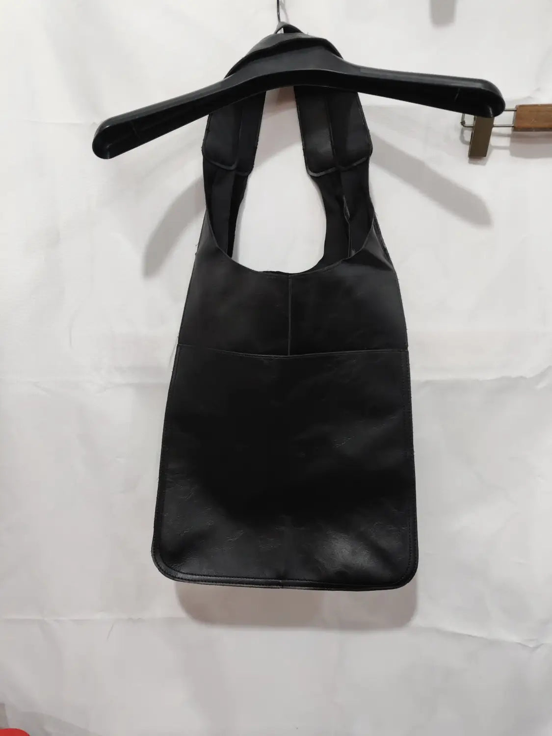 Black leather tote bag with minimalist design, large capacity, soft slouchy structure, and two sturdy shoulder handles.