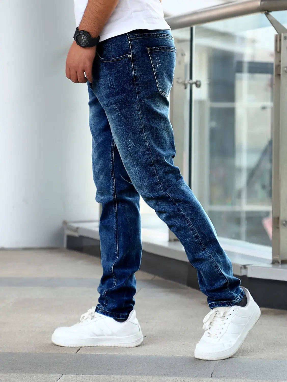 Men’s slim fit distressed dark wash denim jeans made of dark blue denim with subtle fading.