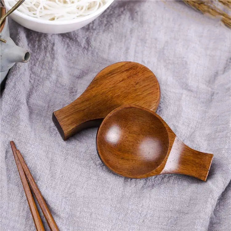 Dos platos pulidos de madera para salsa de inmersión con reposacucharas ergonómicos y acabados cálidos de color marrón liso, diseñados para sostener palillos.