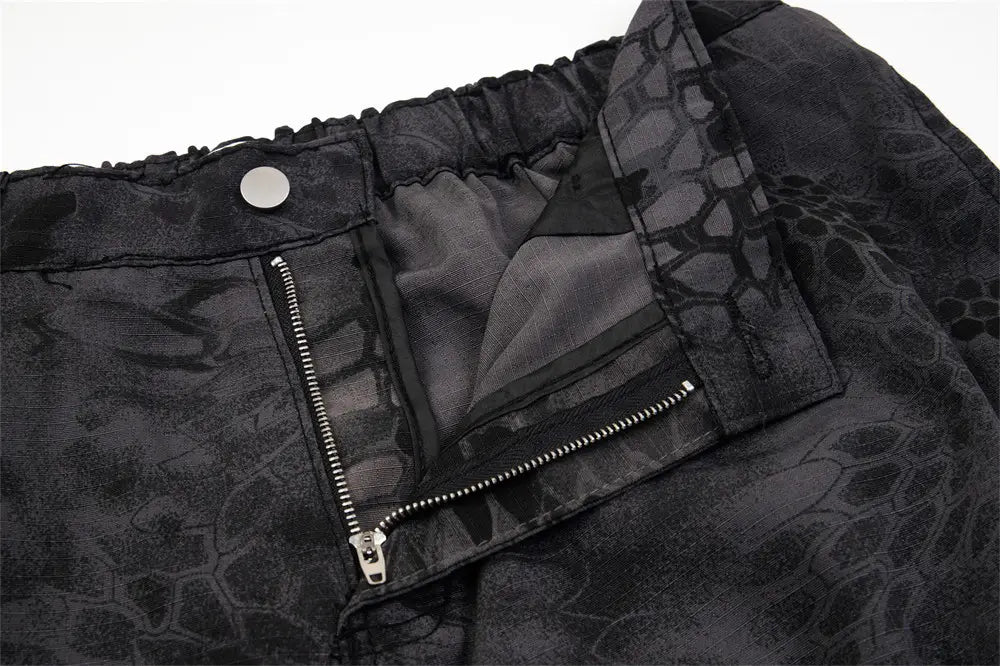 Black camouflage cargo pants with a subtle snakeskin pattern wide leg design and silver zipper details for tactical use