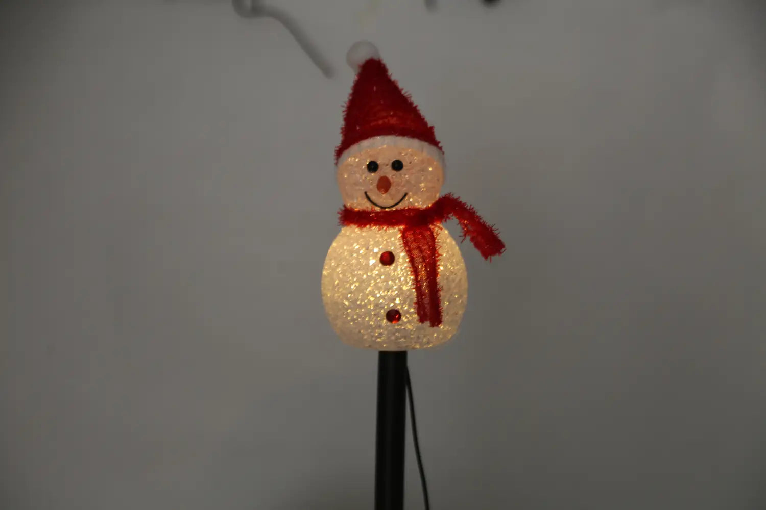 Une décoration de bonhomme de neige texturé lumineux, avec un chapeau et une écharpe rouges, présentée dans un lot de 3 éclairages solaires de jardin en forme de bonhomme de neige, ensemble étanche IP55.