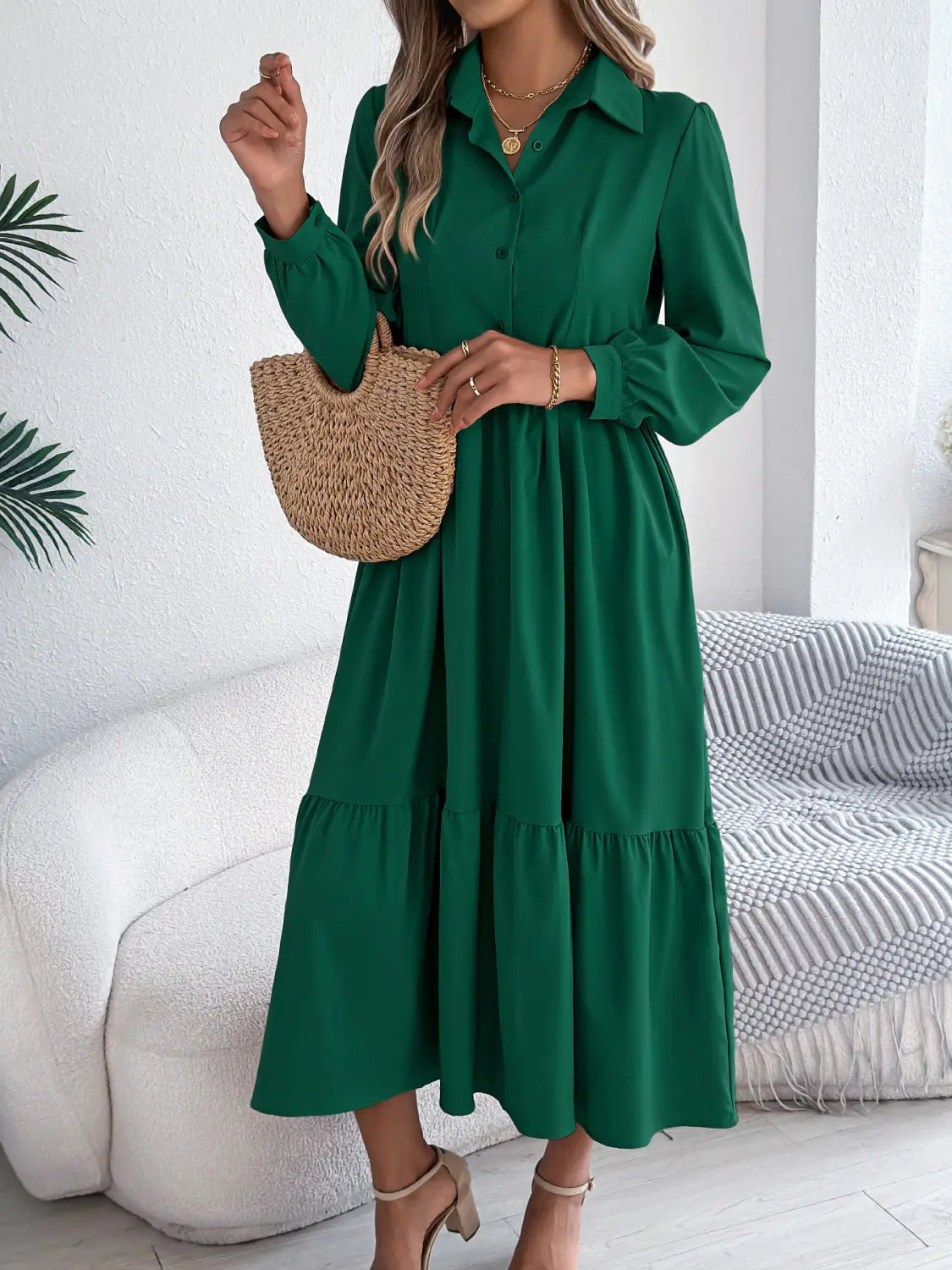 Emerald green women’s long sleeve tiered button down midi dress with collar and flowing skirt made from soft fabric.