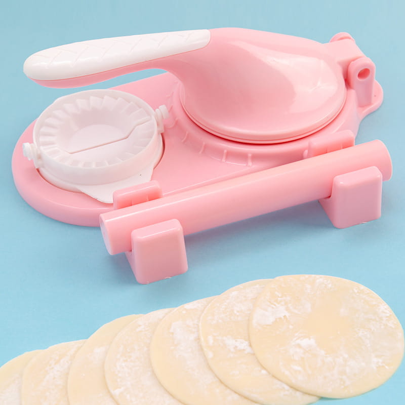 Pink and white plastic dumpling maker 3 in 1 manual dough pressing tool with a rolling pin and circular mold for shaping dough.