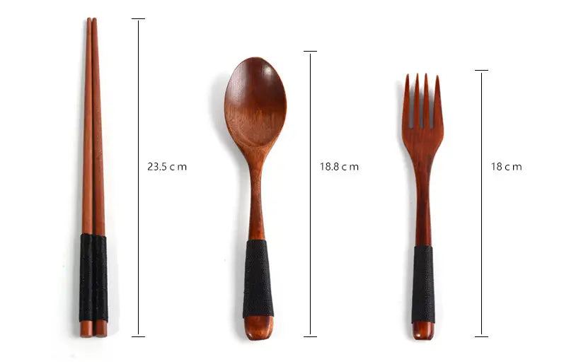 Ensemble de quatre ustensiles de table en bois avec des poignées antidérapantes noires en caoutchouc, dans un coffret de couverts de voyage réutilisable.