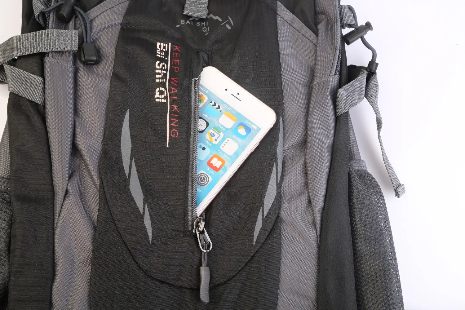 black and gray bai shi qi 36l lightweight waterproof hiking backpack with reflective stripes featuring a front zippered pocket holding an iphone