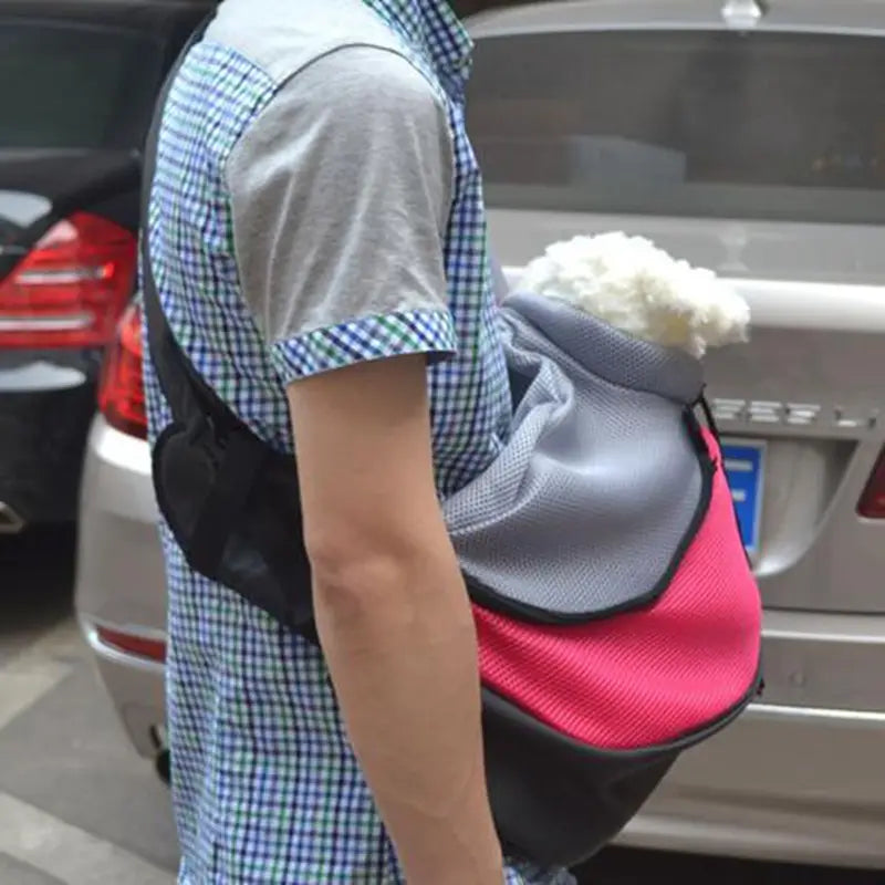 A vibrant pink and gray pet sling carrier bag with black accents features a hands free mesh design for comfortable shoulder carry.