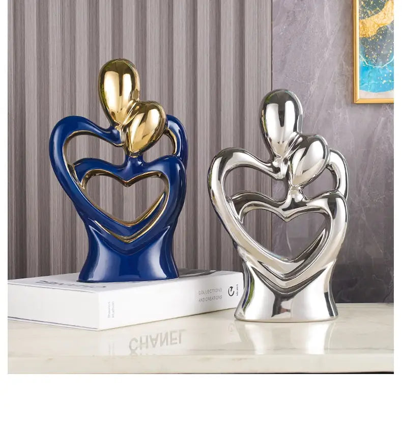 Two glossy ceramic abstract heart figurines in deep blue with gold accents and silver designed as lovers for modern home decor.