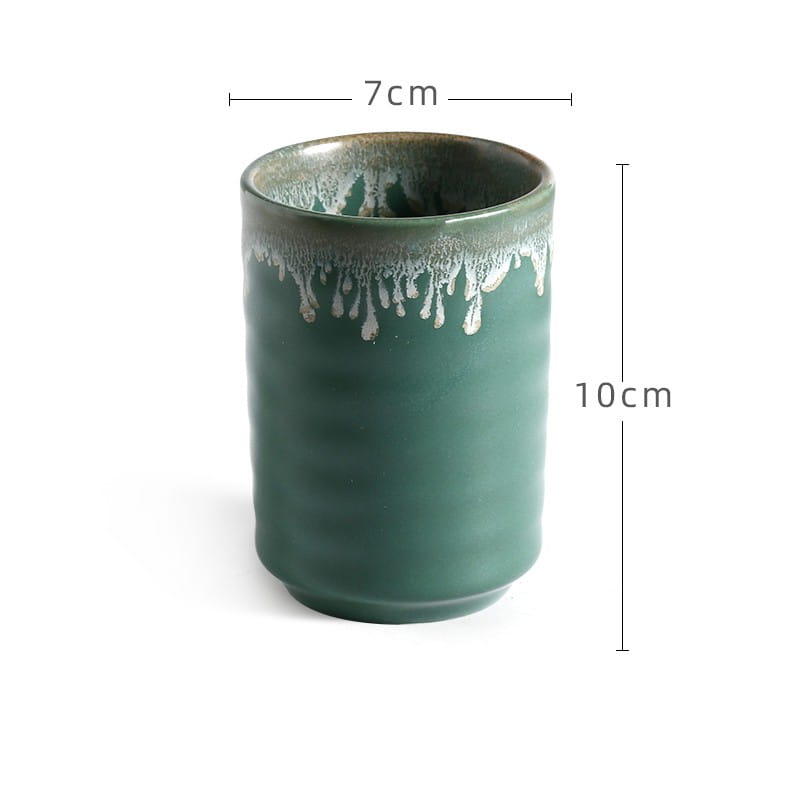 A teal ceramic Japanese mug with a hand-painted glossy textured surface and distinctive white glaze dripping down the rim, ideal for tea drinking.
