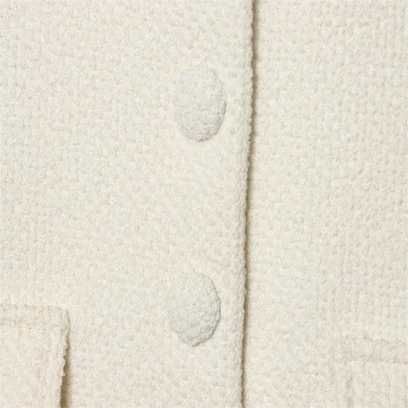 Cream tweed stand collar blazer in cream-colored textured wool with matching button closures.