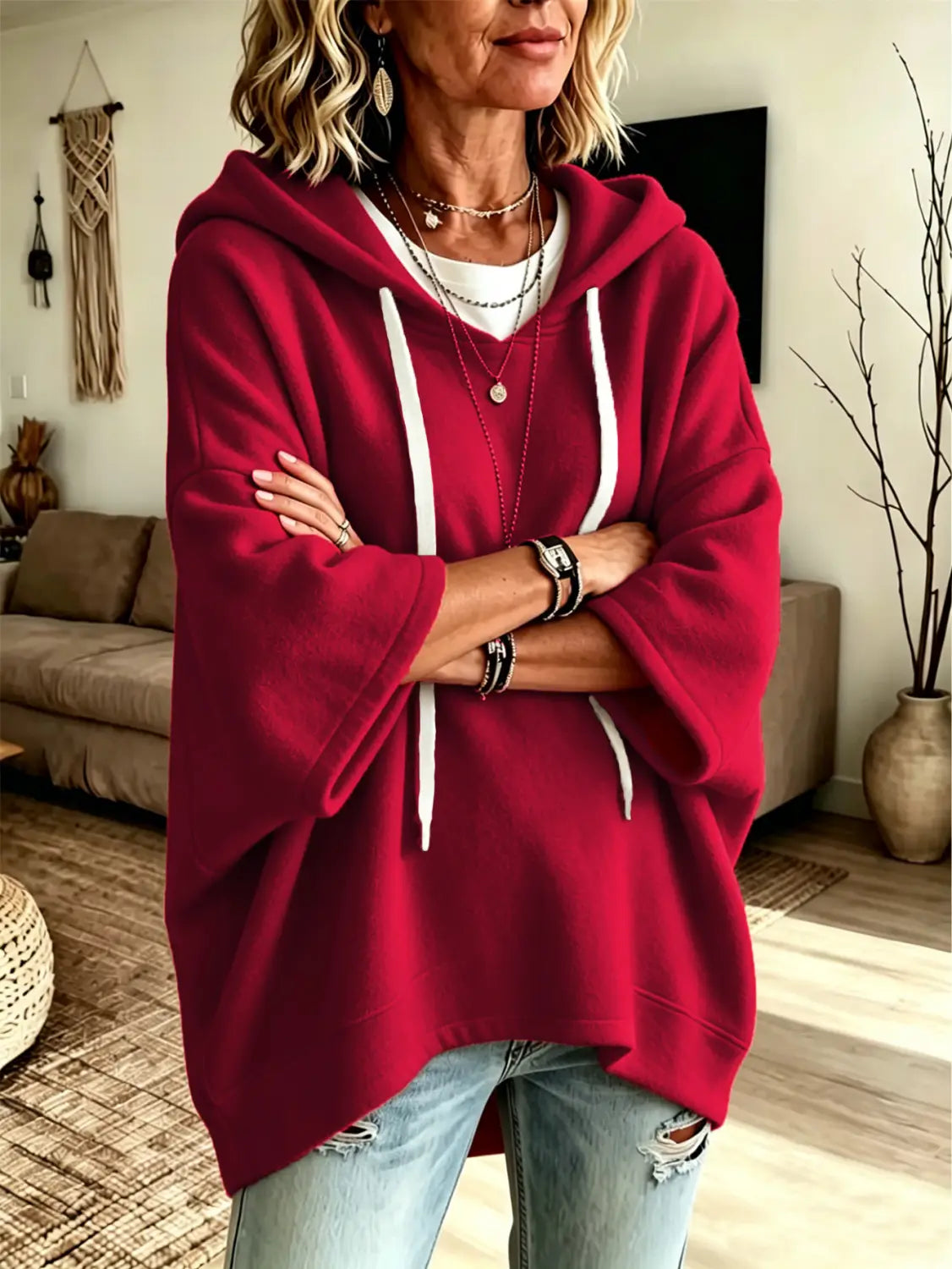 A cozy oversized red fleece hooded top with white drawstrings and three-quarter sleeves featuring a relaxed fit.