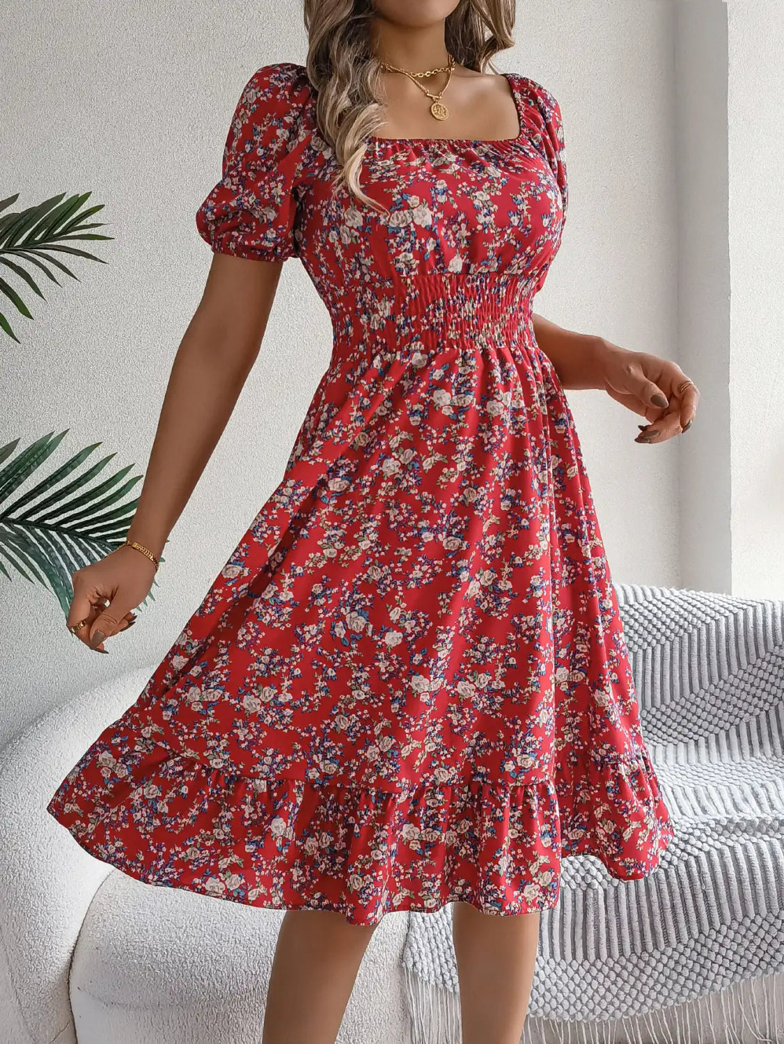 Robe d’été épanouie à imprimé floral rouge vif avec manches courtes bouffantes et encolure carrée.