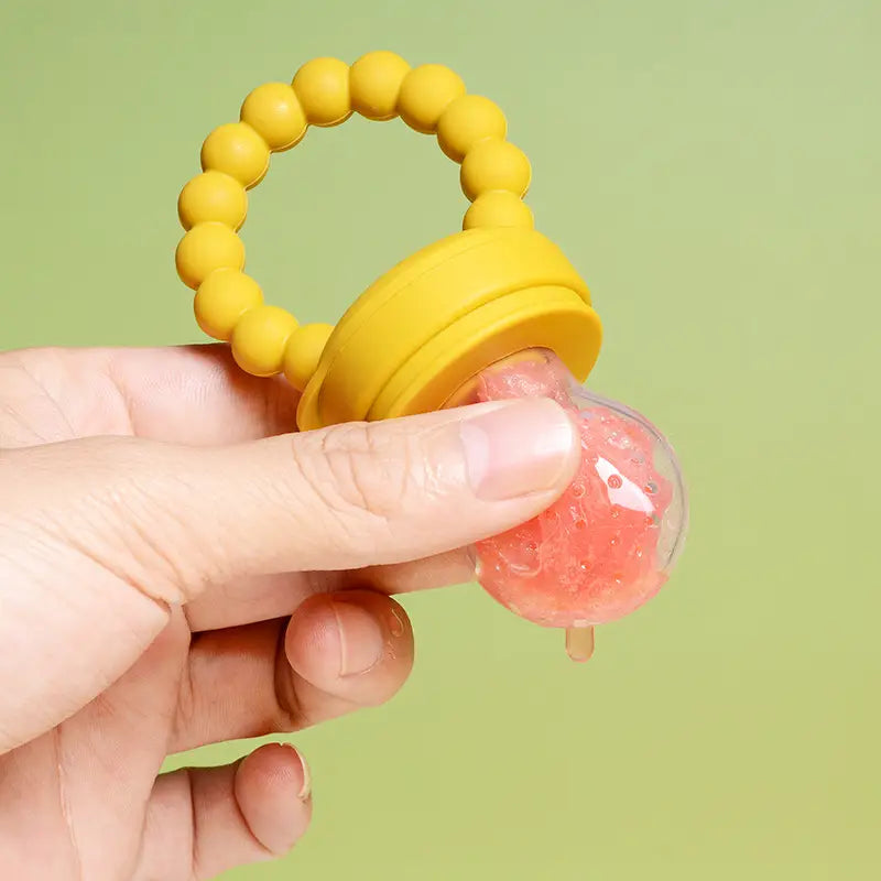 Gelber Babyzahner aus Silikon mit einem transparenten, rosa Gel-gefüllten Ball aus dem Baby-Obstfüttergerät aus Silikon, Teether- und Schnuller-Set.