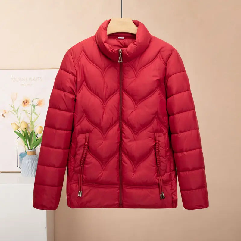 Vibrant red quilted puffer jacket for women with a high collar and heart-shaped stitching pattern designed as a winter coat.