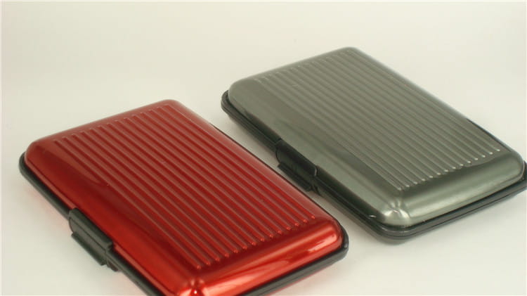 Red and black striped metal card holder made of aluminum alloy featuring RFID blocking technology and a modern ribbed design.