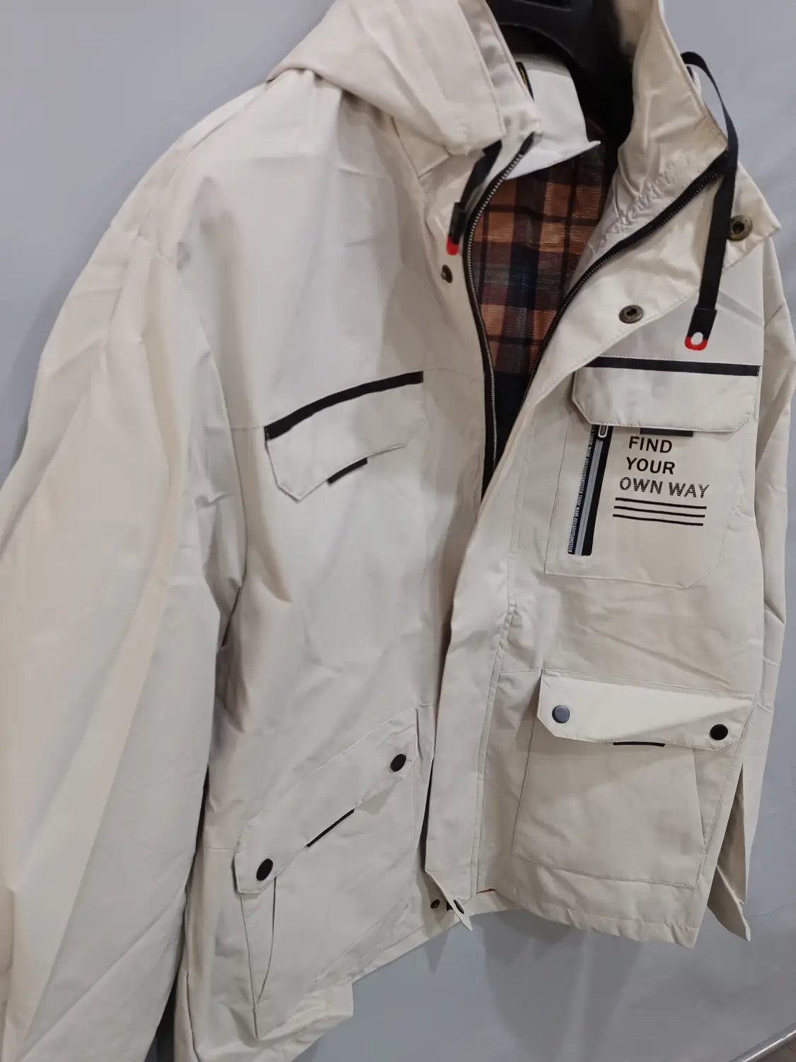 Beige men winter hooded parka coat with black trim button closures and front pocket featuring find your own way text.