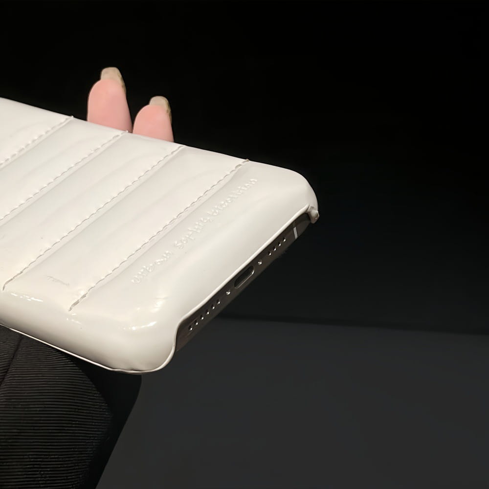 White quilted leather devil horn iPhone case with glossy finish and stitched seams shown from the back side