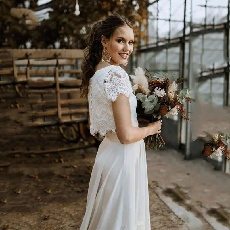 Robe de mariée en dentelle blanche conçue pour un usage nuptial, avec manches bouffantes courtes, décolleté bijou et jupe fluide.