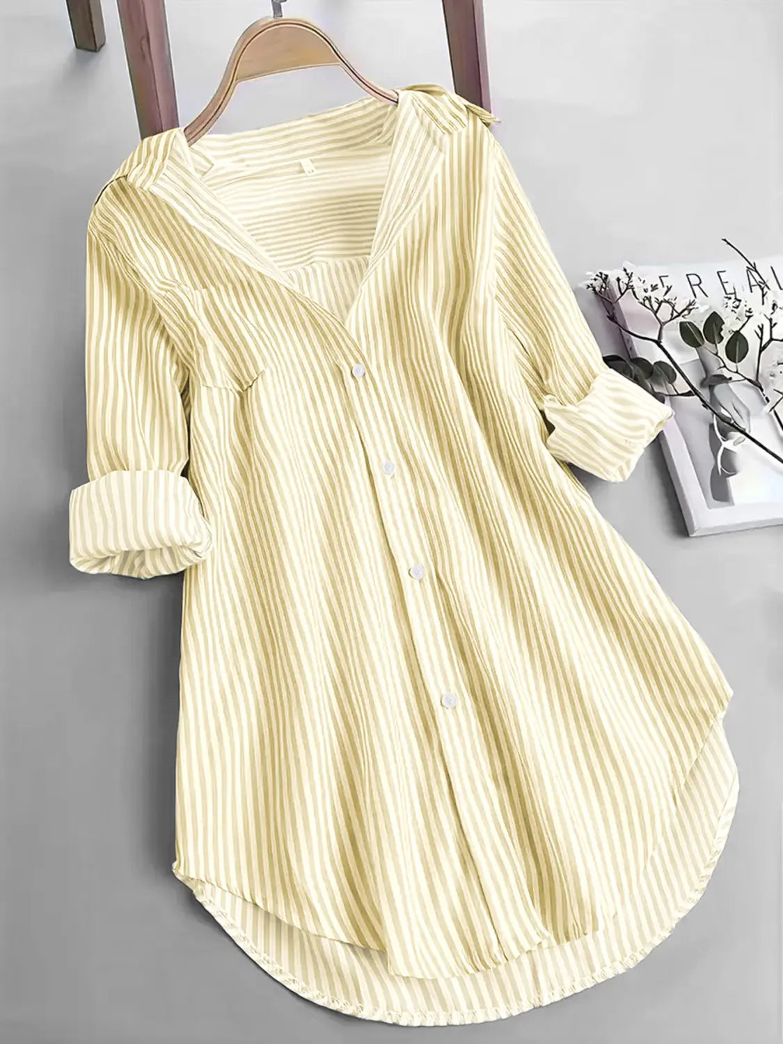 Chemise boutonnée à manches longues à rayures verticales jaune pâle et crème, avec manches retroussées, conçue comme un haut décontracté.
