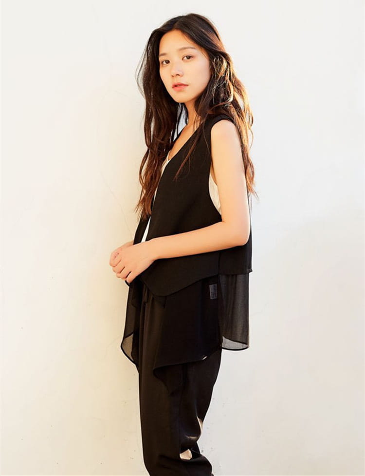 Schwarzer ärmelloser Rock mit Chiffon-Transparent-Overlay und asymmetrischem Saum, als mehrlagiges Fashion-Element konzipiert.