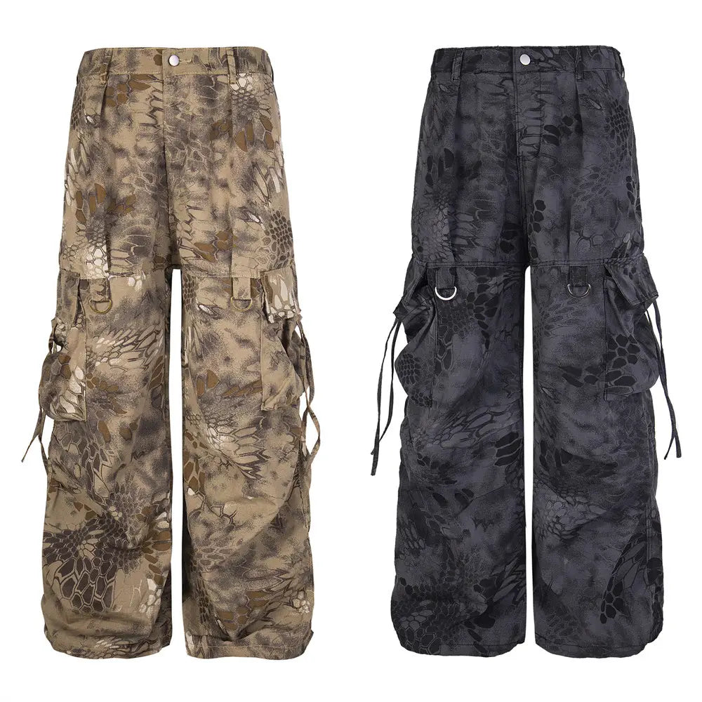 Camouflage cargo pants wide leg tactical trousers in earthy tan and dark gray with leaf-like camouflage pattern and multiple side pockets visible from the back.