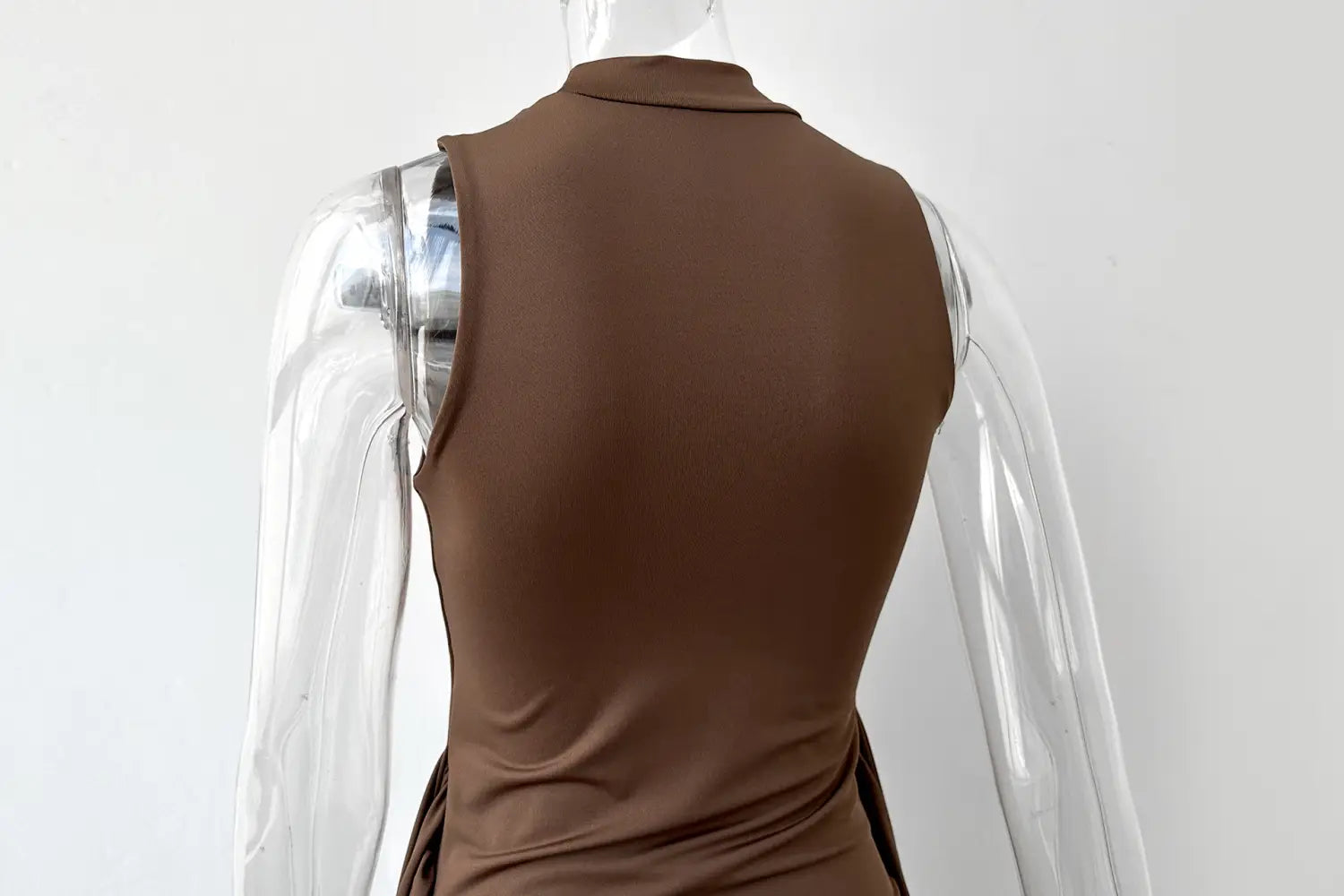 A brown sleeveless midi dress with a high neckline, slim fit silhouette, and a side slit.