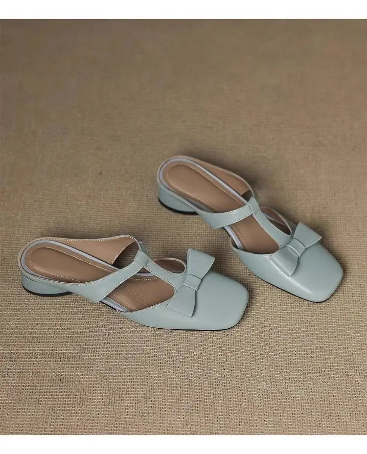 Light blue leather mule flats for women with a square toe and bow detail.