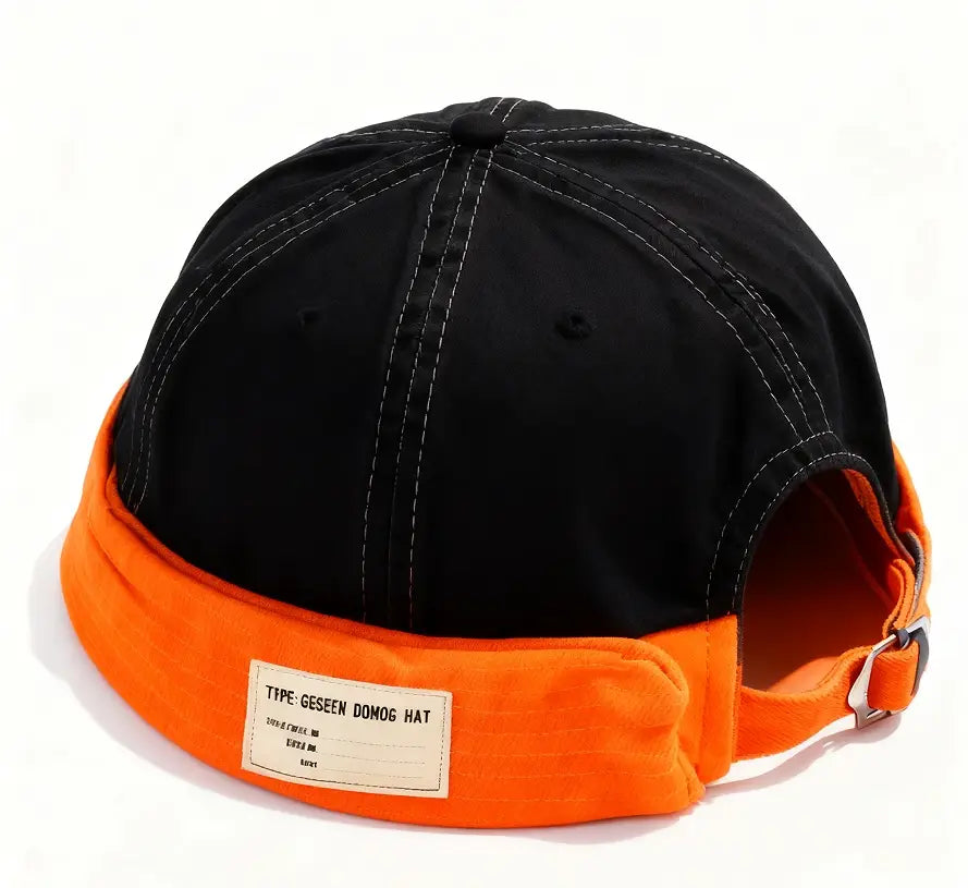 canvas fedora hat for men featuring a black and orange domino cap with contrasting stitching and a branded label, adjustable denim strap shown from the back side.