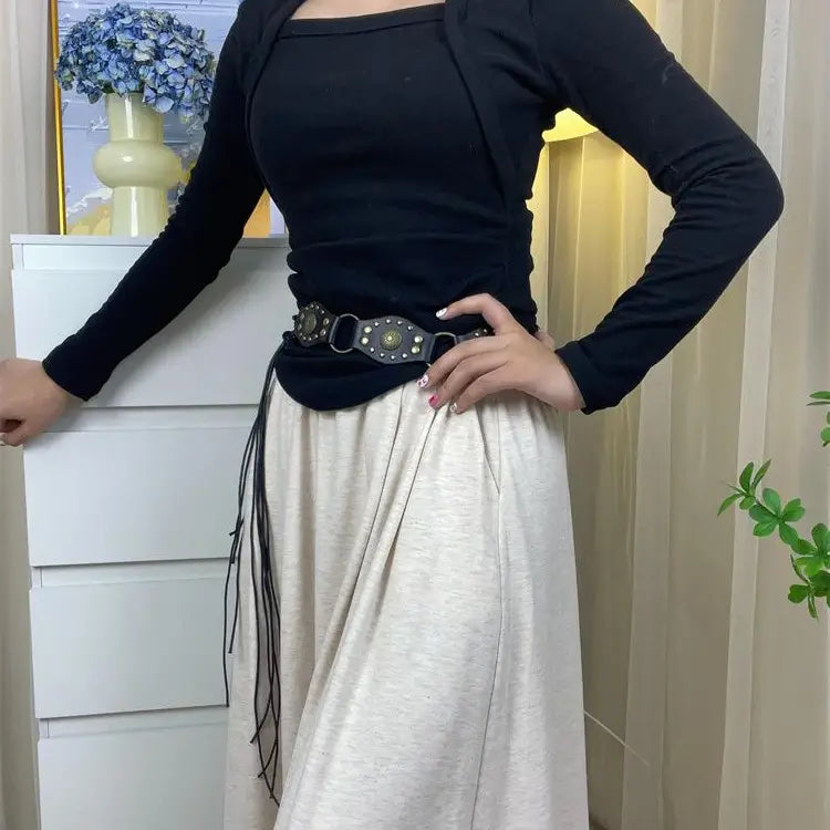 Schwarzer Gothic-Punk-Lederharness-Gurt mit metallischen Nieten, Metallringen und einer zentralen Schnalle mit aufwendig verziertem Detail.