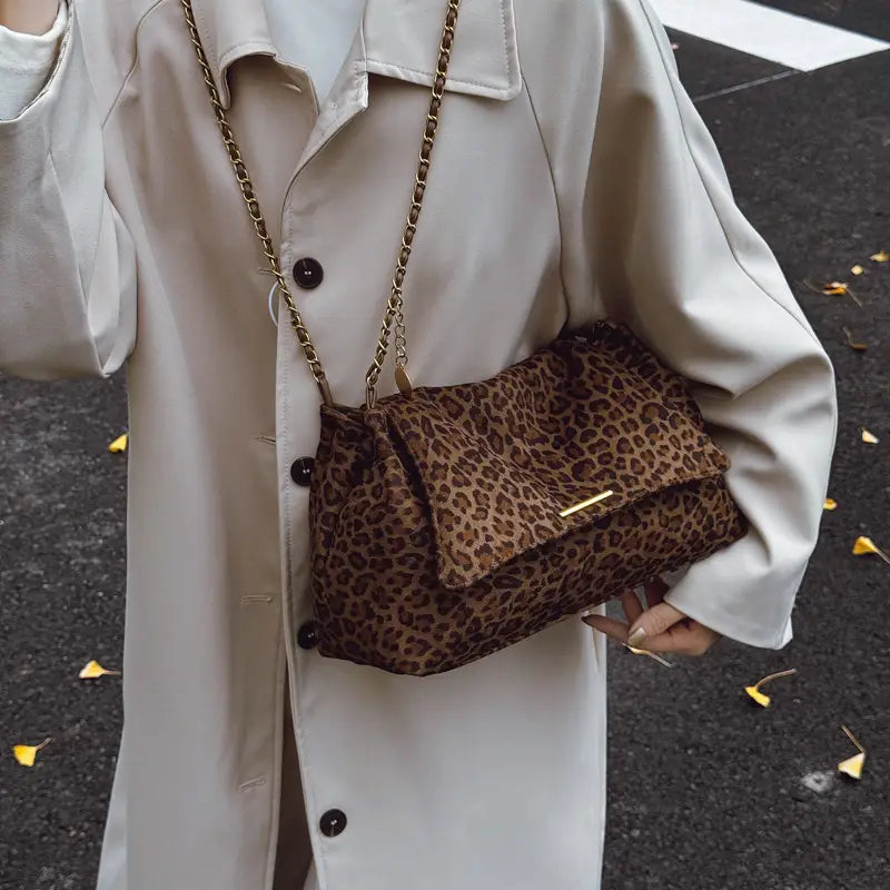 Brown leopard print crossbody bag with gold-tone chain strap and flap closure perfect for stylish everyday use.