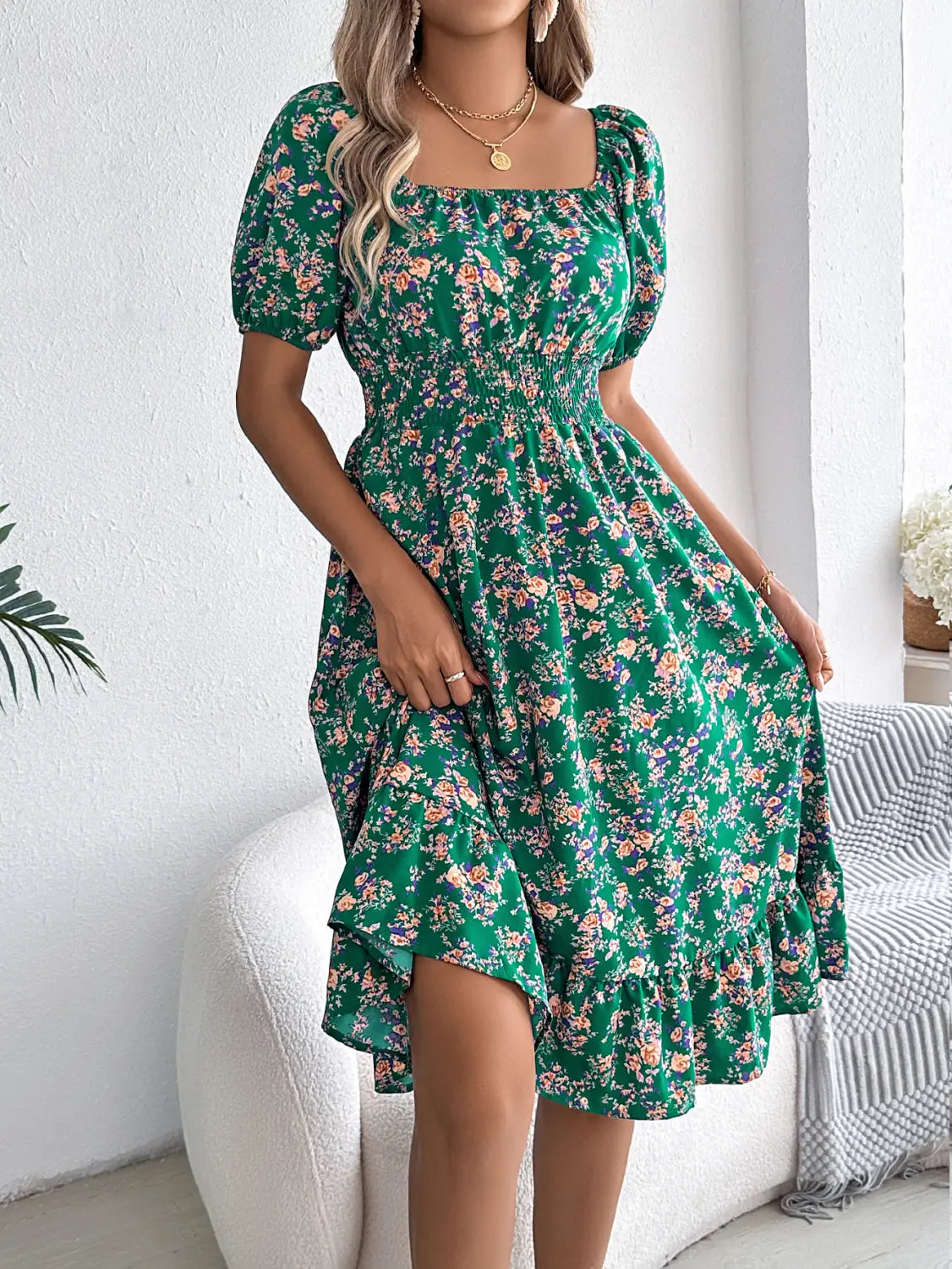 Robe d’été à imprimé floral vert vif, avec manches courtes bouffantes et encolure carrée, présentant des détails à volants.