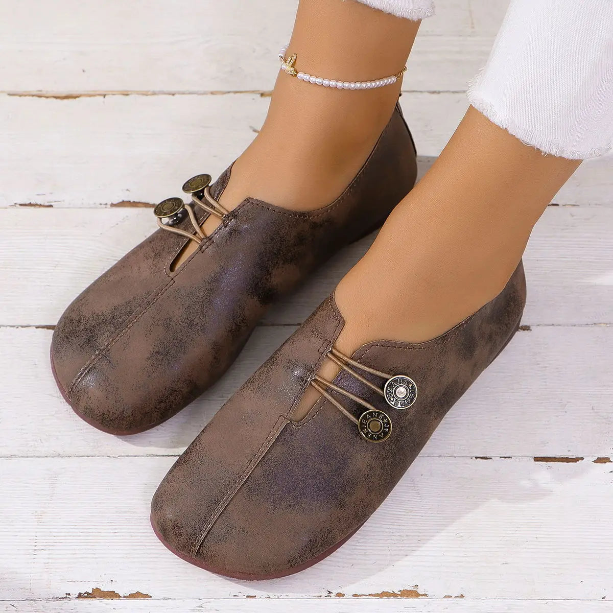 brown distressed leather slip-on flats with decorative metal button closures featured in women’s square toe lace-up leather and suede loafers.