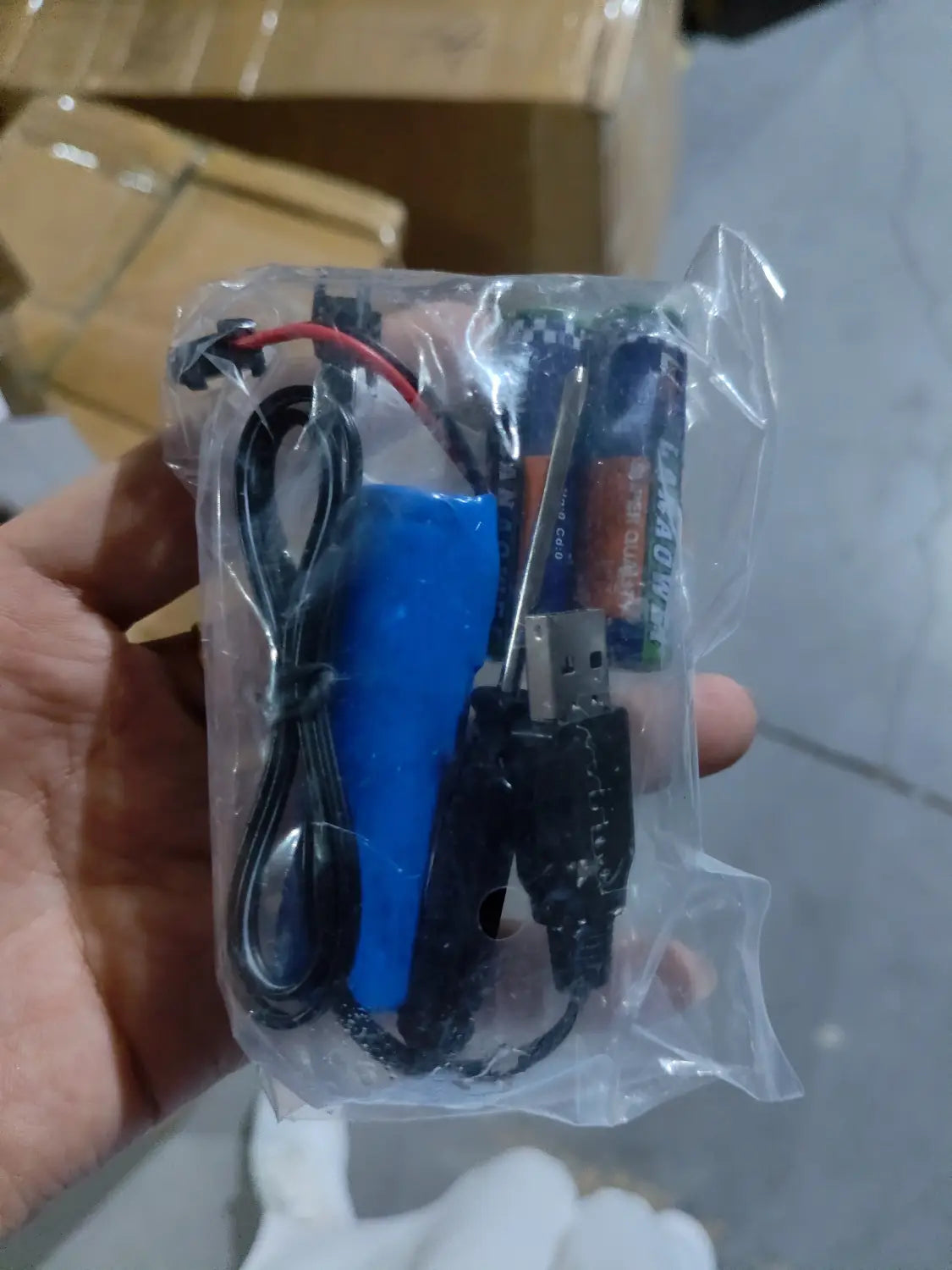 Batería rectangular de ion-litio azul con cable USB negro y cable rojo, empaquetada en una bolsa de plástico transparente para el juguete de camioneta teledirigida RC todoterreno 4WD de alta velocidad