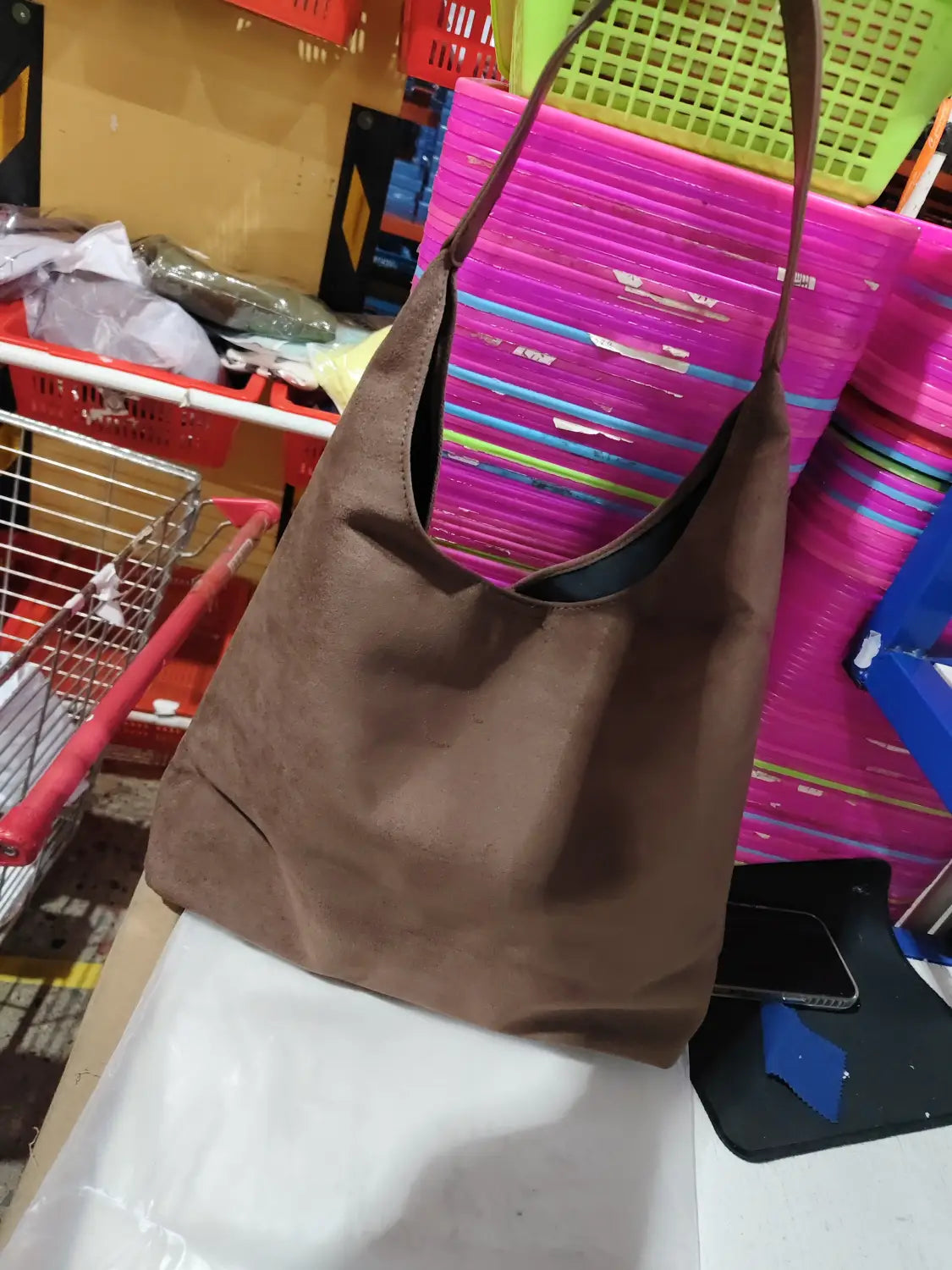 Brown suede slouchy shoulder bag with large capacity, single strap, and black interior lining.