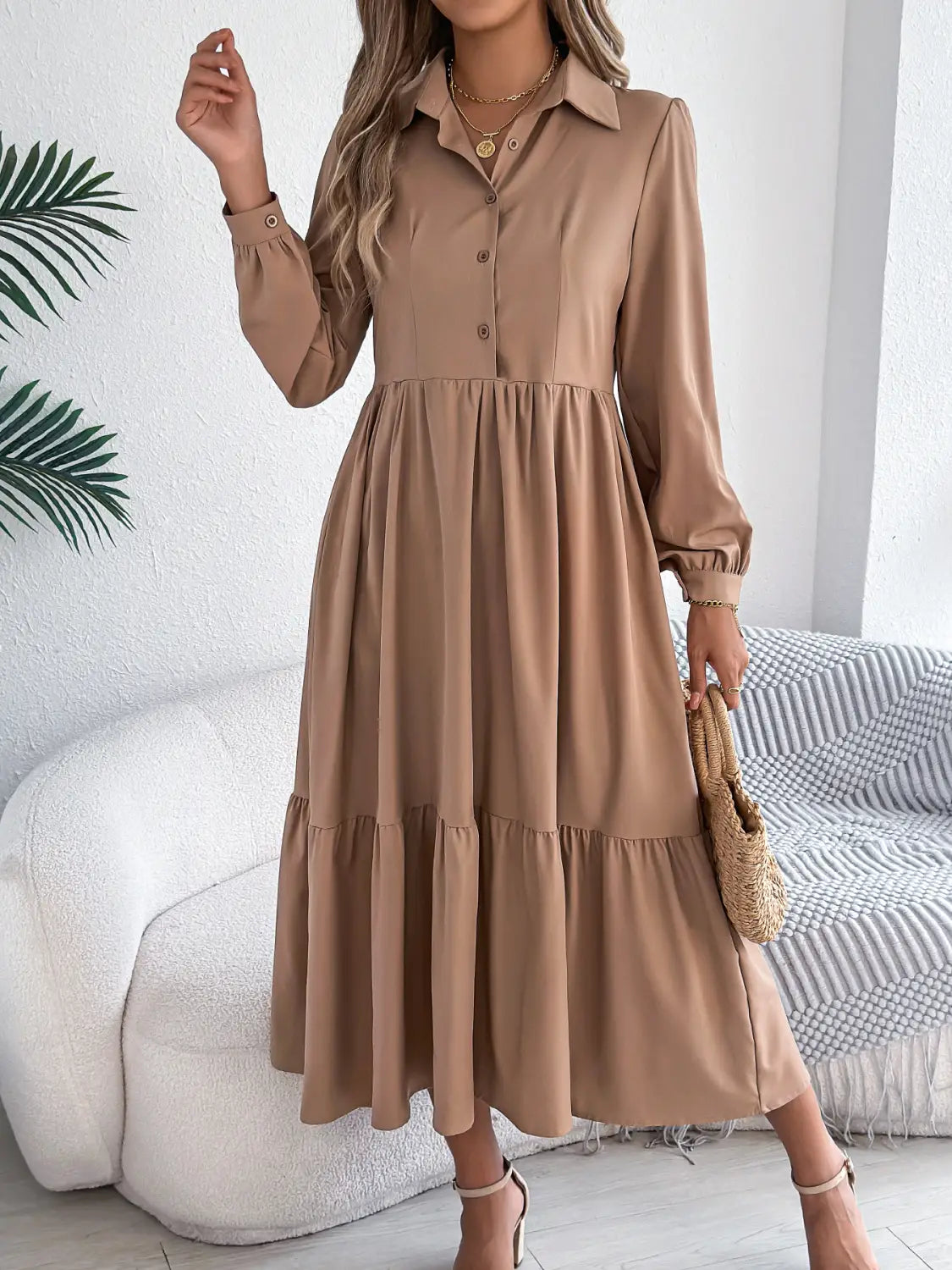 A soft beige women’s long sleeve button down midi dress with a tiered skirt and gathered waist.