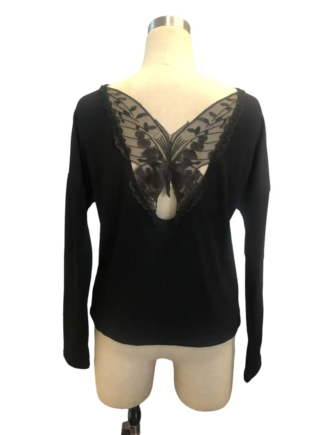 black ribbed long sleeve top shown from the back featuring a delicate butterfly lace detail