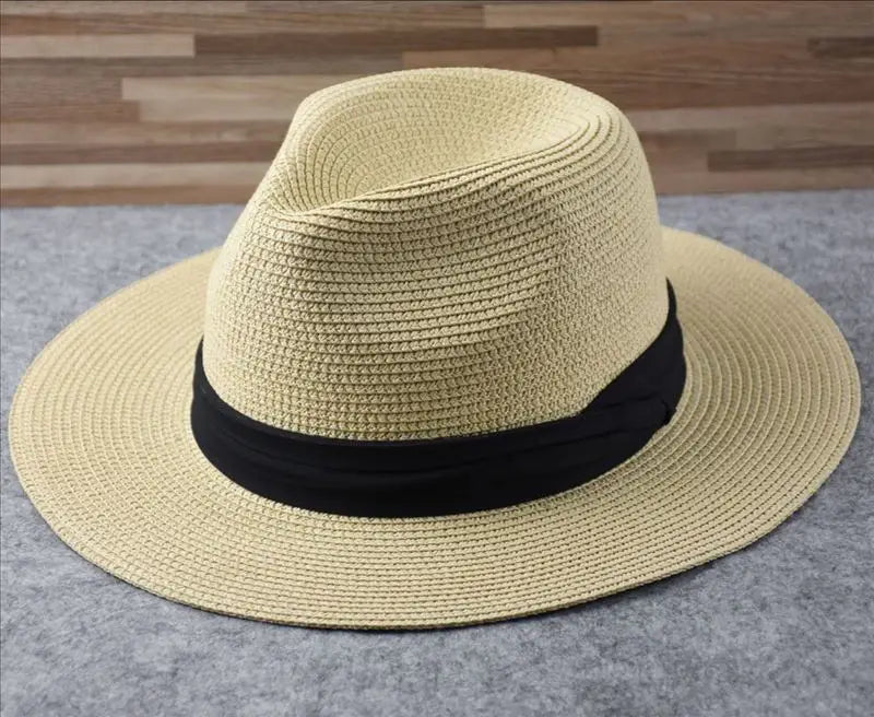 Beige straw fedora hat with black ribbon band foldable for sun protection designed for men.